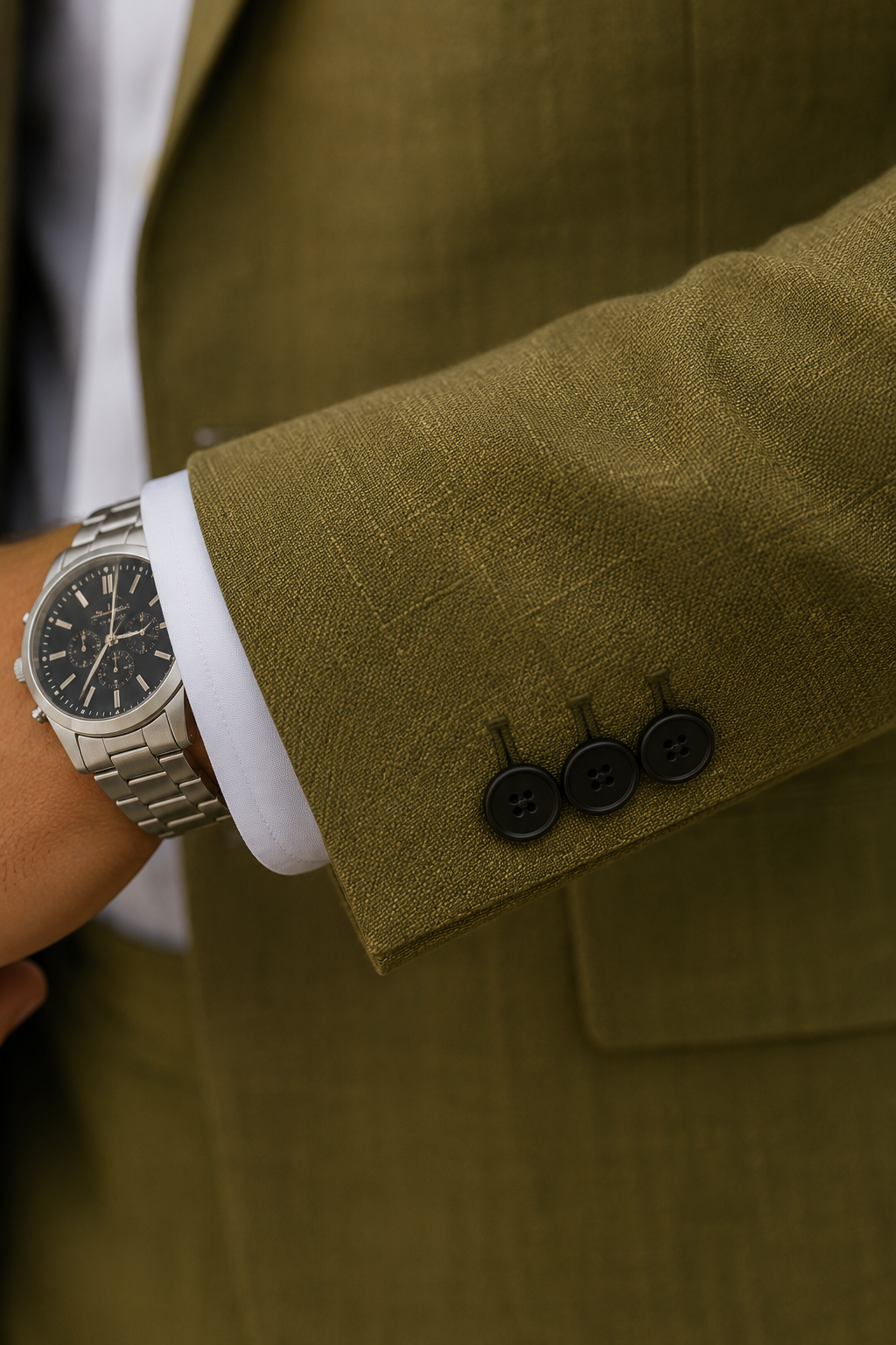 Detail van de ademende linnen-look mouw met knoopjes op colbert